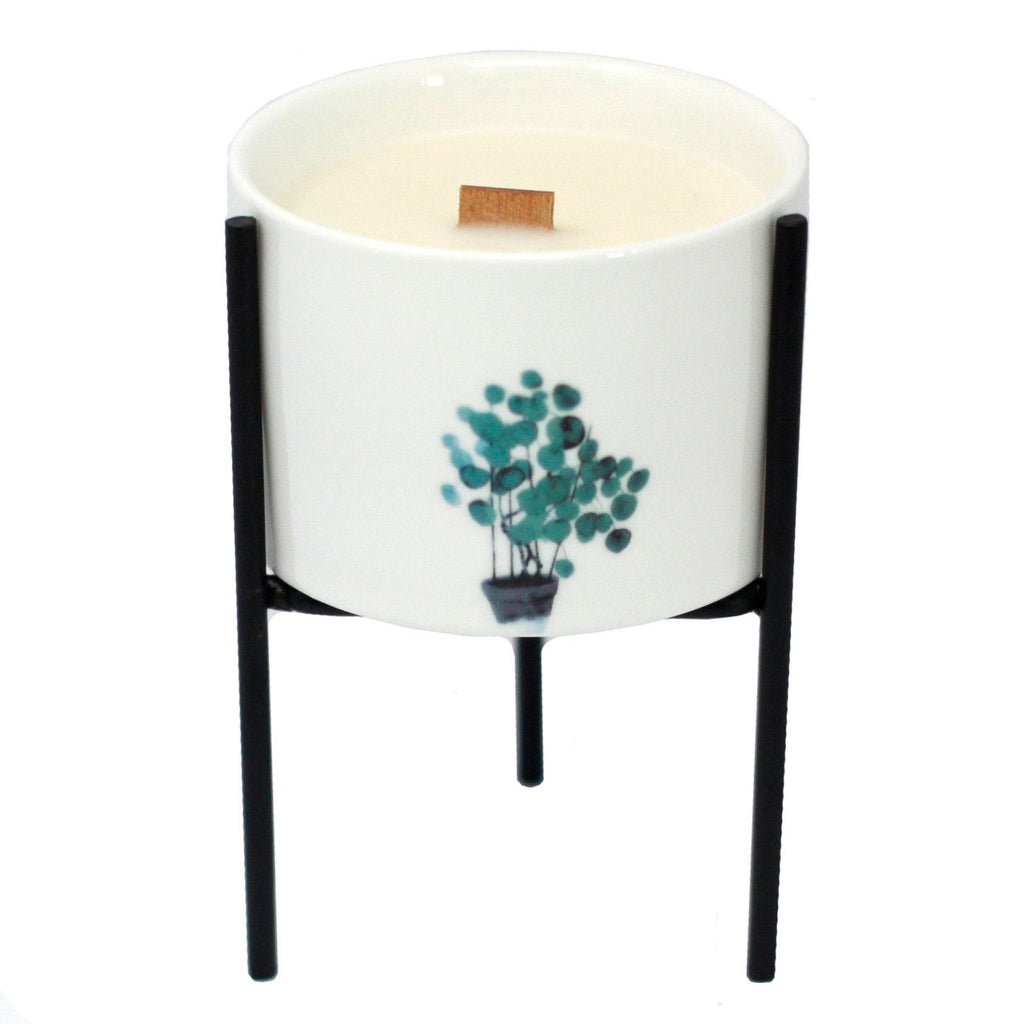 White ceramic candle holder with teal botanical tree print and black iron tripod stand